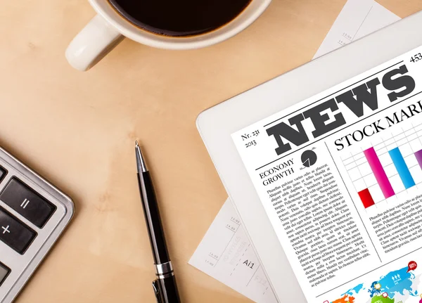 Tablet pc shows news on screen with a cup of coffee on a desk — Stock Photo, Image