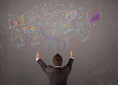 Genç iş adamı çizimlere ve sembollere bakıyor.