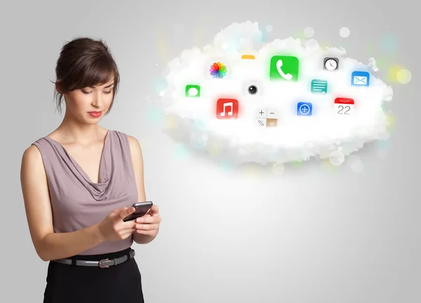 Mulher jovem apresentando nuvem com ícones e símbolos de aplicativos coloridos — Fotografia de Stock
