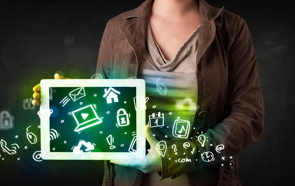 Person holding tablet with green media icons and symbols — Stock Photo, Image