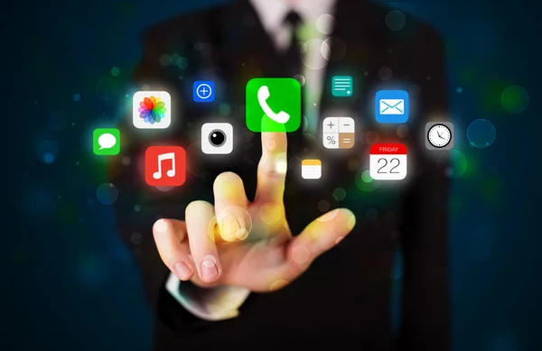 Hombre de negocios guapo presionando iconos coloridos aplicación móvil con bok —  Fotos de Stock