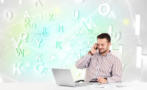 Business man at desk with green word cloud — Stock Photo, Image