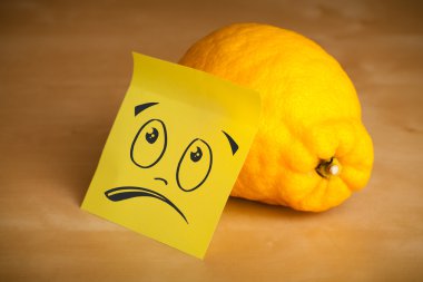 Yapışkan not ile gülen yüze limon yapışabilir