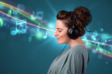 Kulaklıkla müzik dinleyen genç bir kadın.