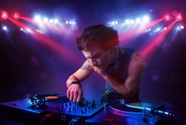 Genç dj kayıtları bir kalabalığın önünde sahnede karıştırma