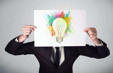 boya sıçraması ve lightbul ile bir karton tutan işadamı