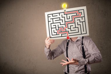 bir labirent ile bir kağıt üzerinde h tutan işadamı