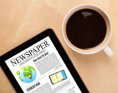 Tablet bilgisayarı haberleri ekranda bir fincan kahveyle sunar.