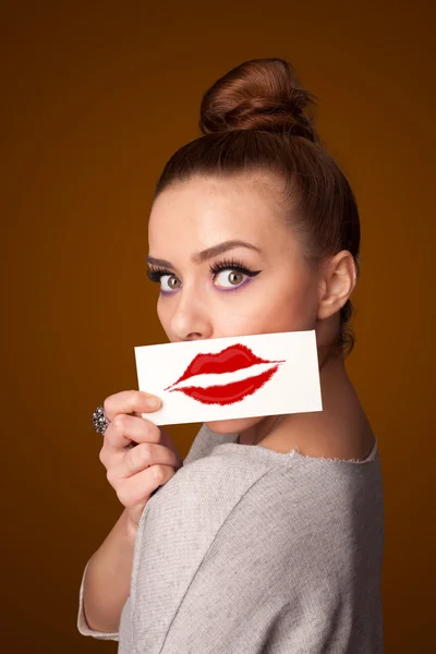 Happy pretty woman holding card with kiss lipstick mark — Stock Photo, Image