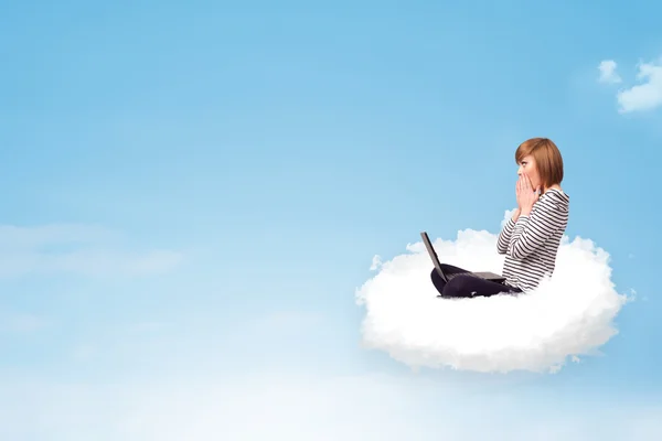 Jonge vrouw met laptop zitting op wolk met kopie ruimte — Stockfoto