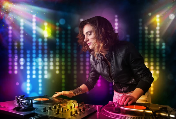 Dj menina tocando músicas em uma discoteca com show de luz — Fotografia de Stock