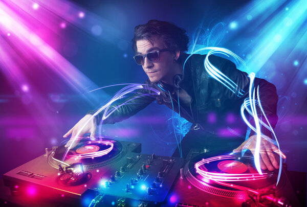 Energetic Dj mixing music with powerful light effects