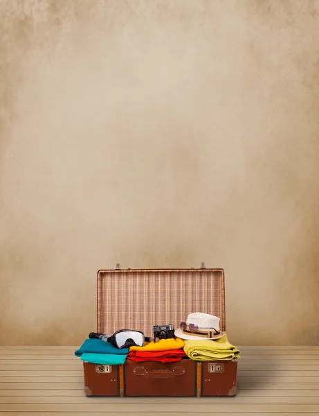 Retro tourist luggage with colorful clothes and copyspace — Stock Photo, Image