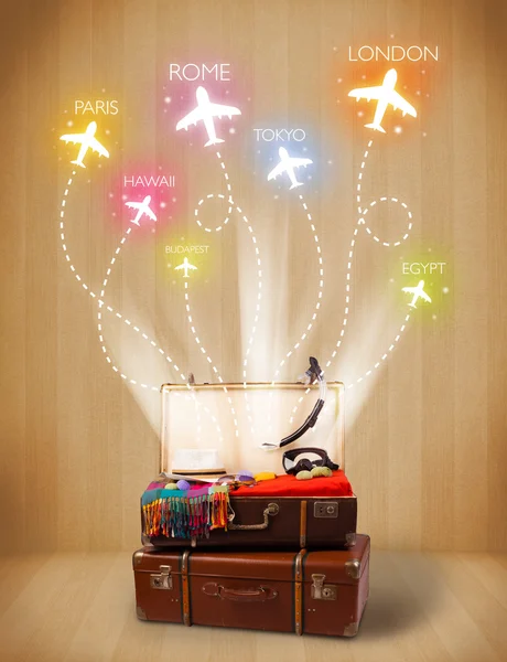 Travel bag with clothes and colorful planes flying out — Stock Photo, Image