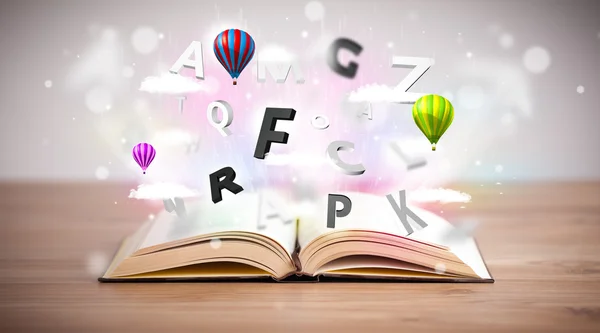 Open book with flying 3d letters on concrete background — Stock Photo, Image