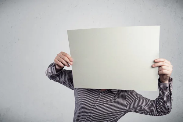 Üzletember, aki egy papírt tart a feje előtt, fénymásolási hellyel. — Stock Fotó