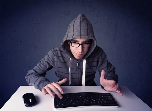 ハッカーは青い背景でキーボードで作業しています — ストック写真