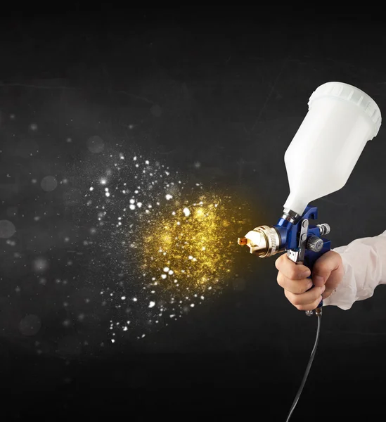 Trabajador con pintura de aerógrafo con pintura dorada brillante —  Fotos de Stock