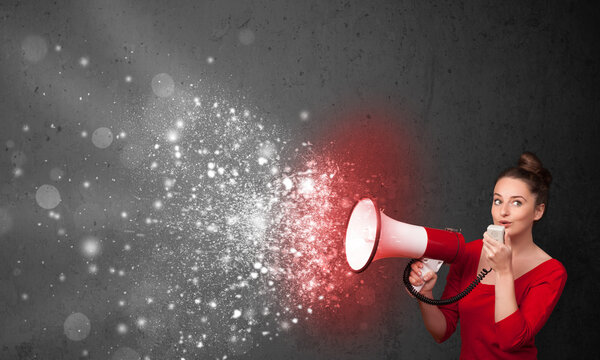 Женщина кричит в мегафон и исследует светящиеся частицы энергии
