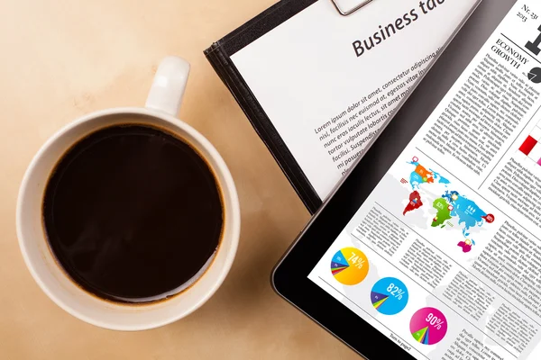 Tablet pc visar nyheter på skärmen med en kopp kaffe på ett skrivbord — Stockfoto