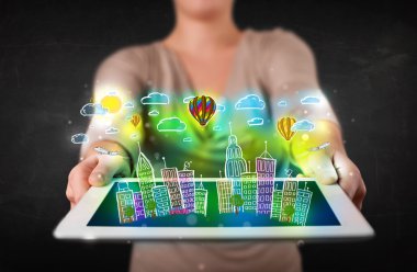 Elle çizilmiş şehir manzaralı tablet gösteren genç kişi