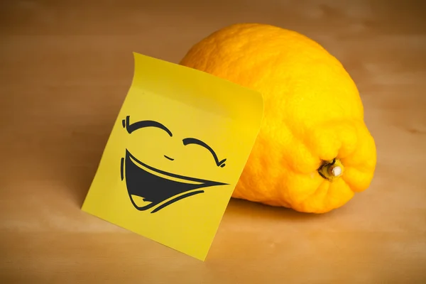 Post-it note avec le visage souriant collé sur le citron — Photo