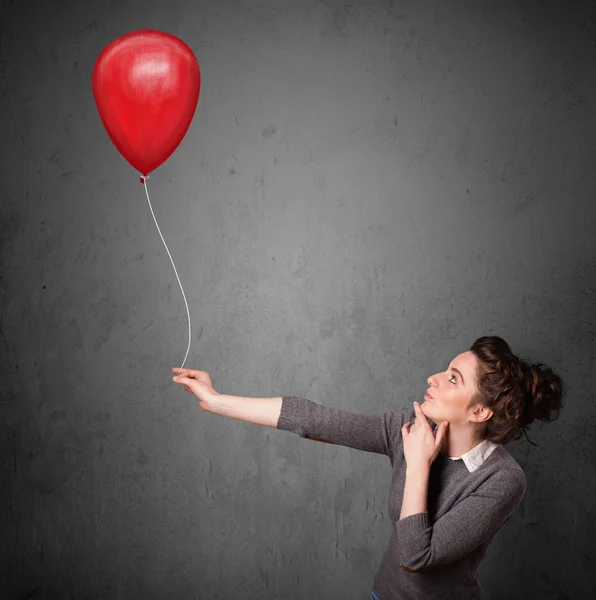 Mujer sosteniendo un globo rojo — Foto de Stock