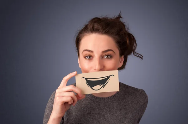 Feliz linda chica sosteniendo papel con divertido dibujo sonriente —  Fotos de Stock