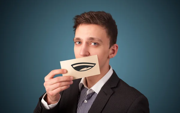 Happy businessman holding funny white card on his mouth — Stock Photo, Image