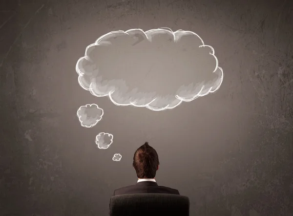 Byznysmen sedí s mraky myšlenek nad hlavou — Stock fotografie