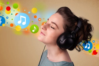 Kulaklıkla müzik dinleyen genç bir kadın. 