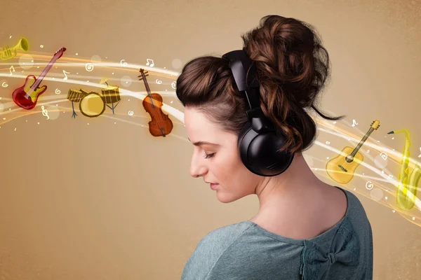 Ung kvinna med hörlurar lyssnar på musik — Stockfoto