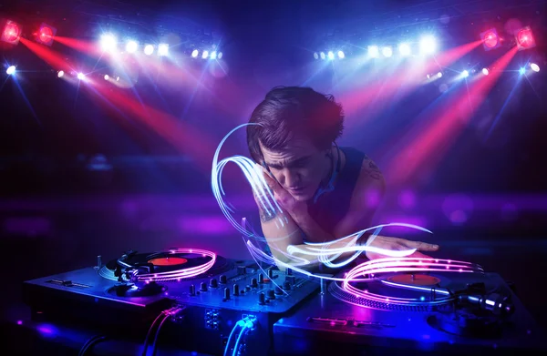 Disc jockey jouant de la musique avec des effets de faisceau lumineux sur scène — Photo