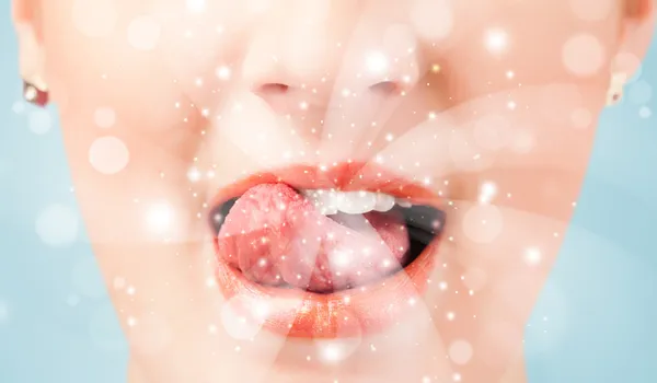 Pretty woman lips blowing abstract white lights — Stock Photo, Image