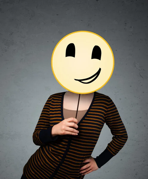 Junge Frau mit einem Smiley-Emoticon — Stockfoto