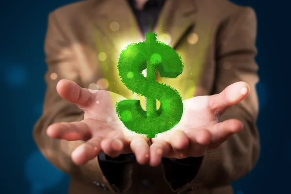 Giovane uomo d'affari che presenta verde segno luminoso dollaro — Foto Stock