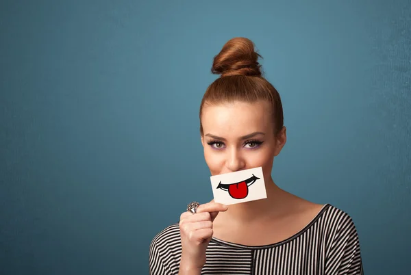 Happy pretty woman holding card with funny smiley — Stock Photo, Image