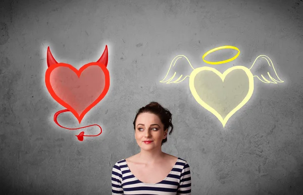 Femme debout entre l'ange et les cœurs du diable — Photo