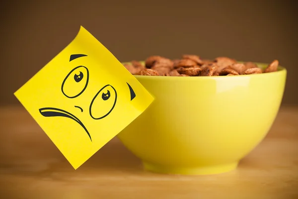 Post-it notera med smiley ansikte klistras på spannmål skål — Stockfoto