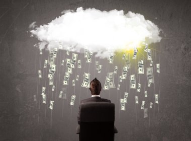 Takım elbiseli bir iş adamı düşen parayla bulutlara bakıyor.