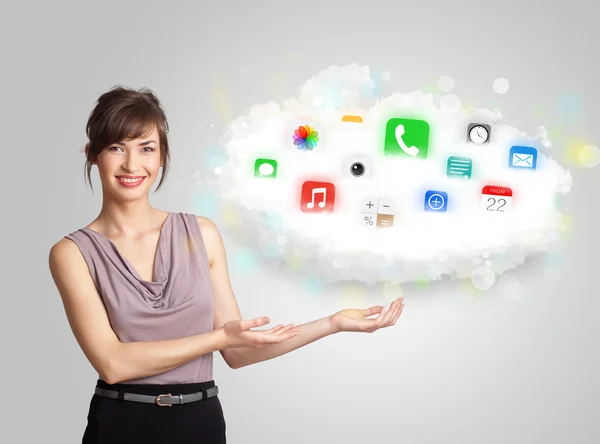 Mujer joven presentando nube con iconos de aplicaciones de colores y símbolos — Foto de Stock