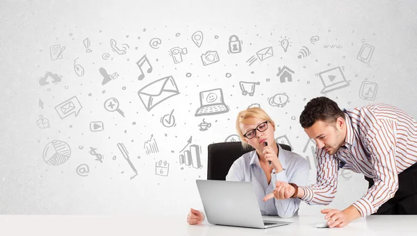 Geschäftsmann und Frau sitzen mit handgezeichneten Medien am Tisch — Stockfoto