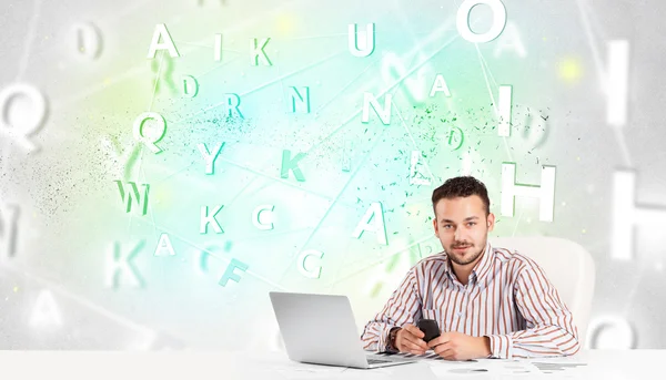 Business man at desk with green word cloud — Stock Photo, Image