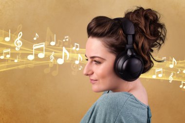 Kulaklıklı genç bir kadın müzik dinliyor.