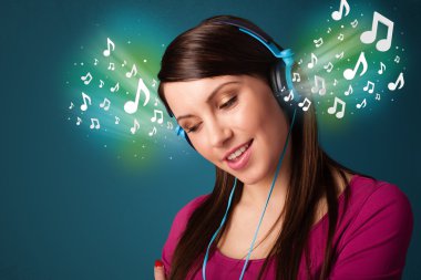 Kulaklıklı genç bir kadın müzik dinliyor.