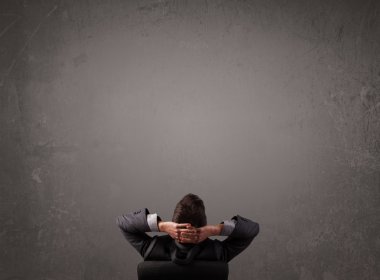 kopya alanı bir duvarın önünde oturan işadamı