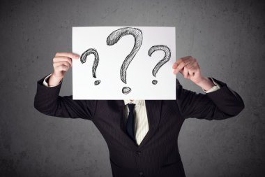 onun önünde soru işareti olan bir kağıt tutan işadamı 