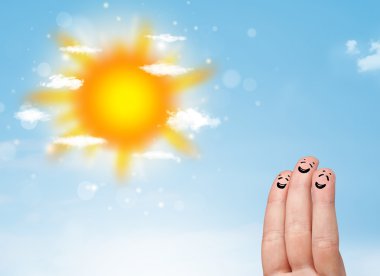 Parlak güneş ve bulutların çizdiği neşeli parmak gülümsemeleri