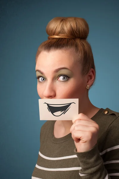 Felice ragazza carina in possesso di carta con divertente disegno smiley — Foto Stock