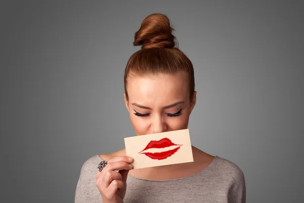 Happy pretty woman holding card with kiss lipstick mark — Stock Photo, Image